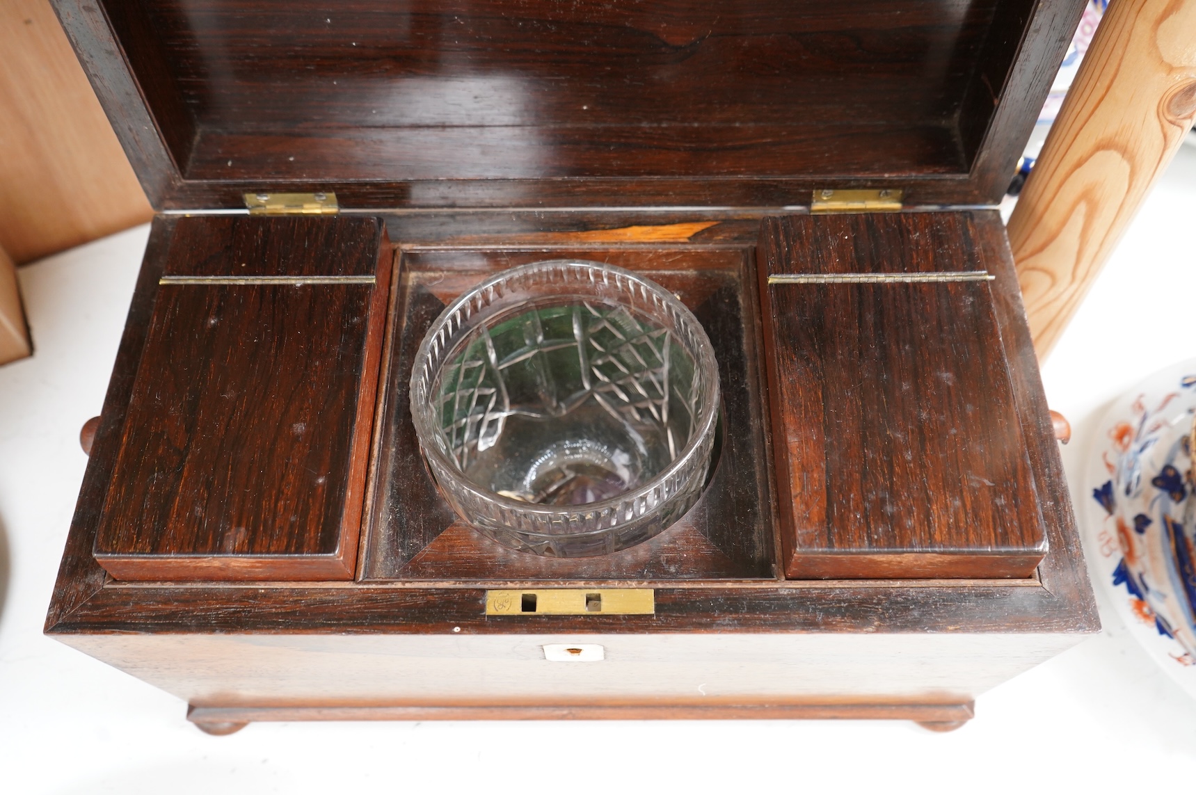 A William IV rosewood sarcophagus shaped tea caddy with glass liner, 33cm wide